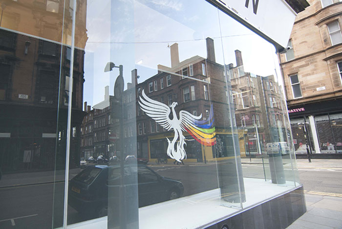 documentation photo detail of a window mural of a white phoenix with a rainbow trail from its left wing